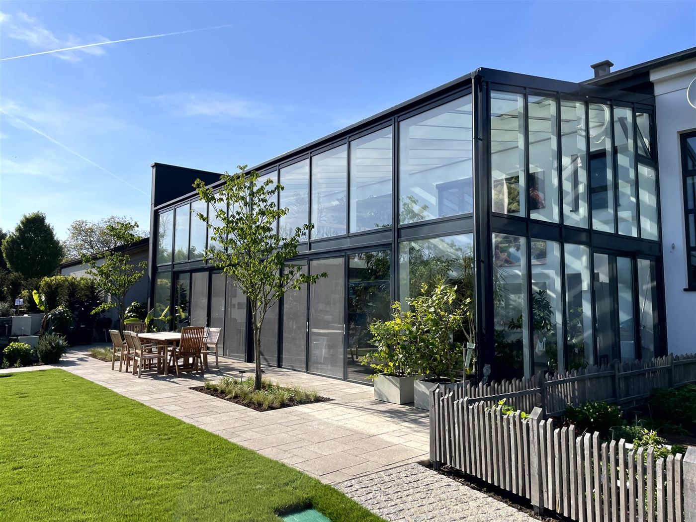 Glasfassade des Bürogebäudes mit Rasen und Terrasse