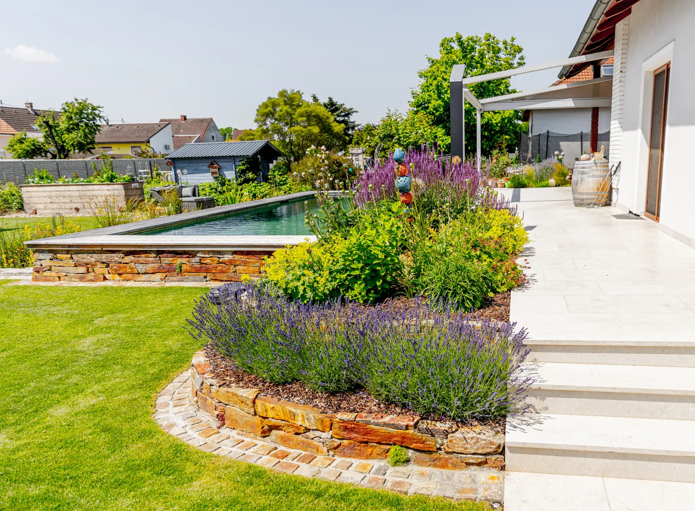 Blick über den Naturpool zum Garten