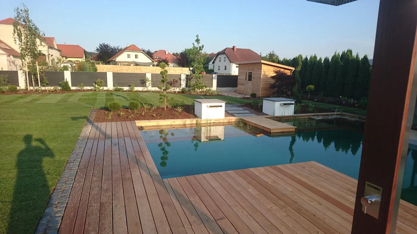 Holzdeck ragt über das Wasser des Schwimmteichs