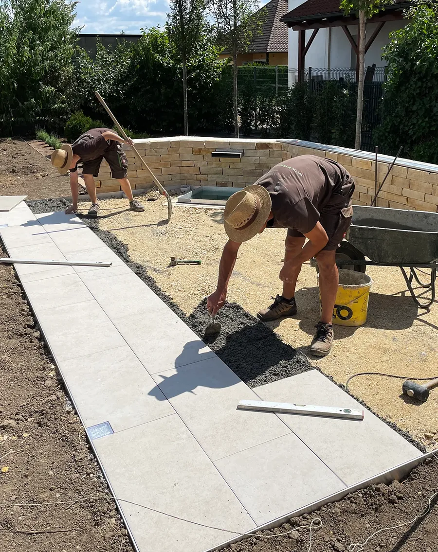 Zwei Mitarbeiter verlegen großformatige Terrassenplatten