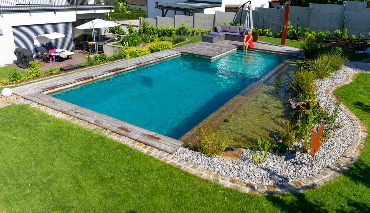 Schwimmteich mit Sonnenschirm und angrenzender Terrasse